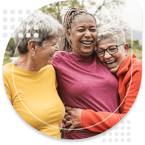 Happy multiracial senior women having fun together outdoor - Elderly generation people hugging each other at park