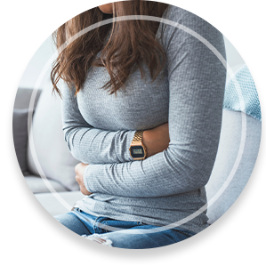 Woman lying on sofa looking sick in the living room. Beautiful young woman lying on bed and holding hands on her stomach. Woman having painful stomachache on bed, Menstrual period