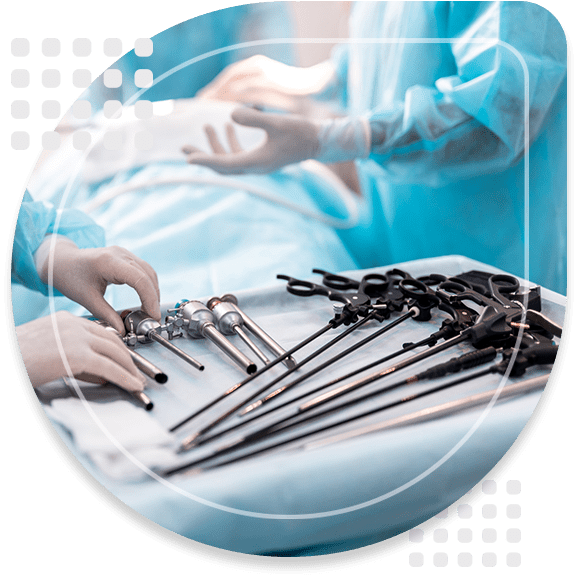 Close up of female hands in sterile gloves holding trocar for laparoscopy procedure. Laparoscopic scissors and graspers on white desk