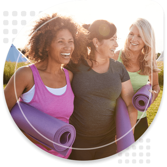 Group Of Mature Female Friends On Outdoor Yoga Retreat Walking Along Path Through Campsite