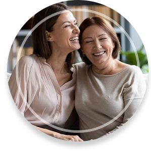 Happy senior mother and grownup daughter sit relax on couch in living room talk laugh and joke, smiling overjoyed middle-aged mom and adult girl child rest at home have fun enjoying weekend together